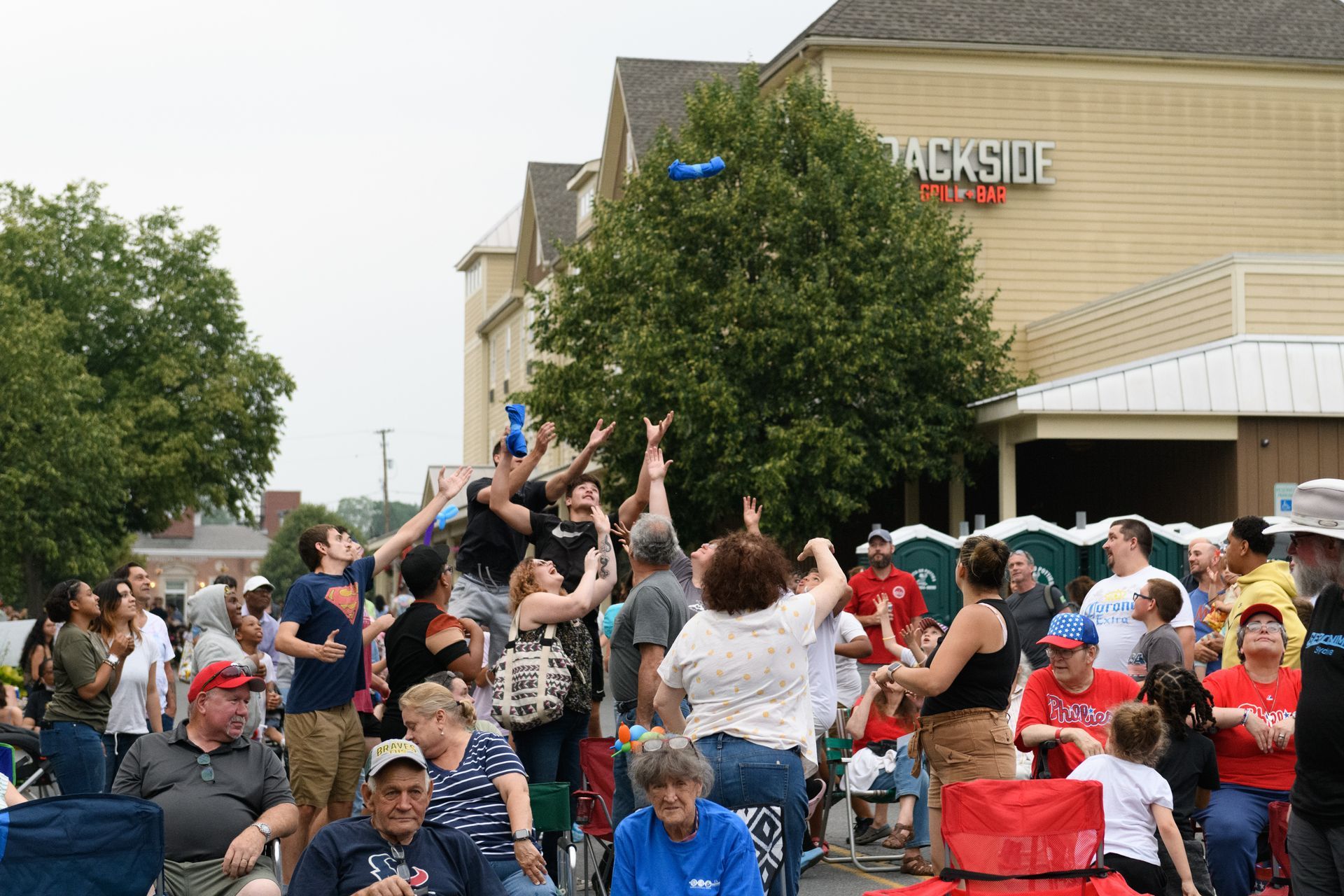 A large group of people are gathered in front of a hotel.
