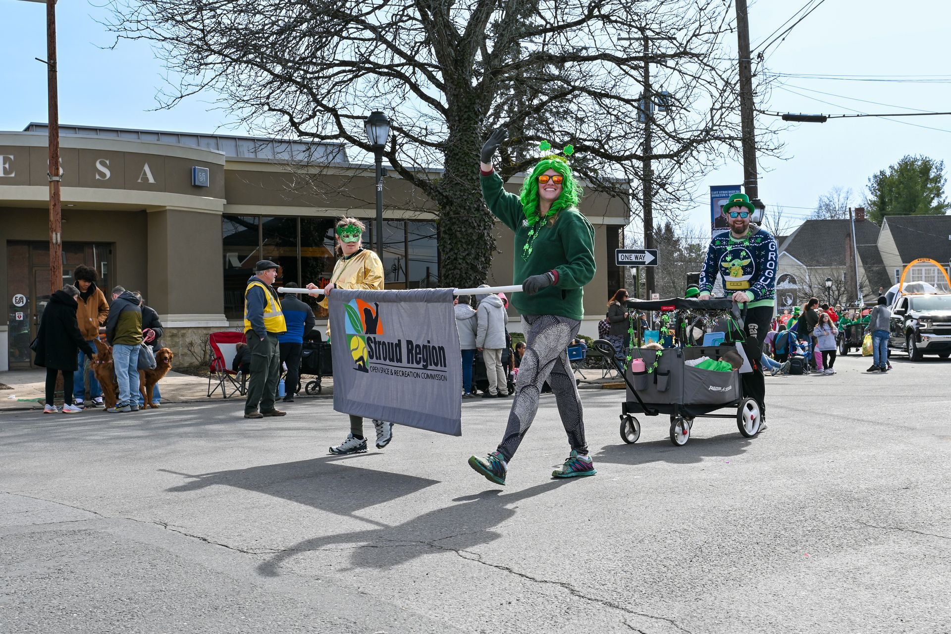 A group of people are marching down a street in a parade.