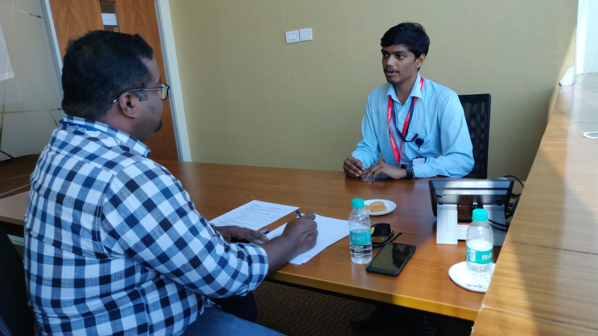 Two men are sitting at a table having a conversation.