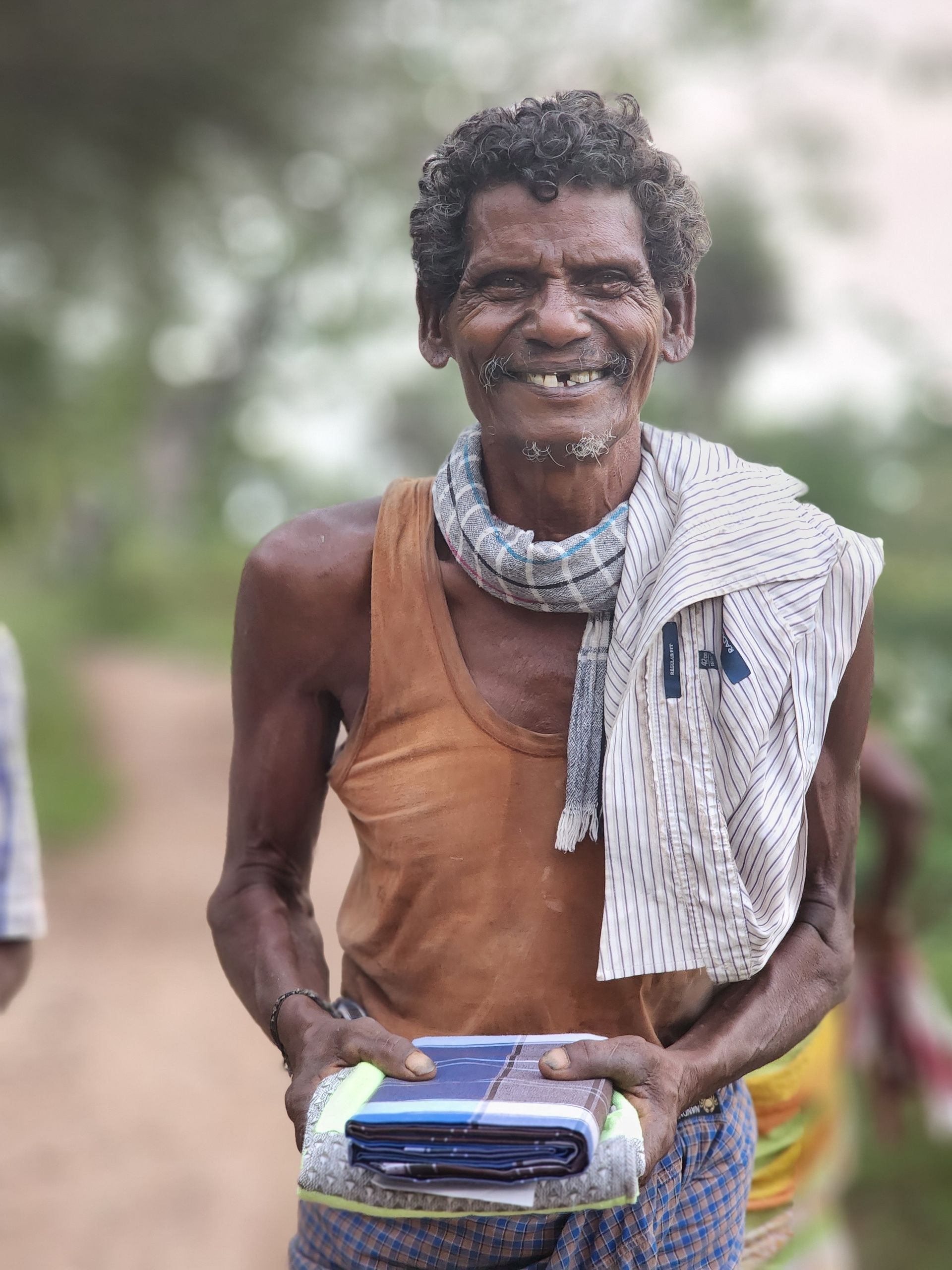 A man is smiling and holding a box in his hands.