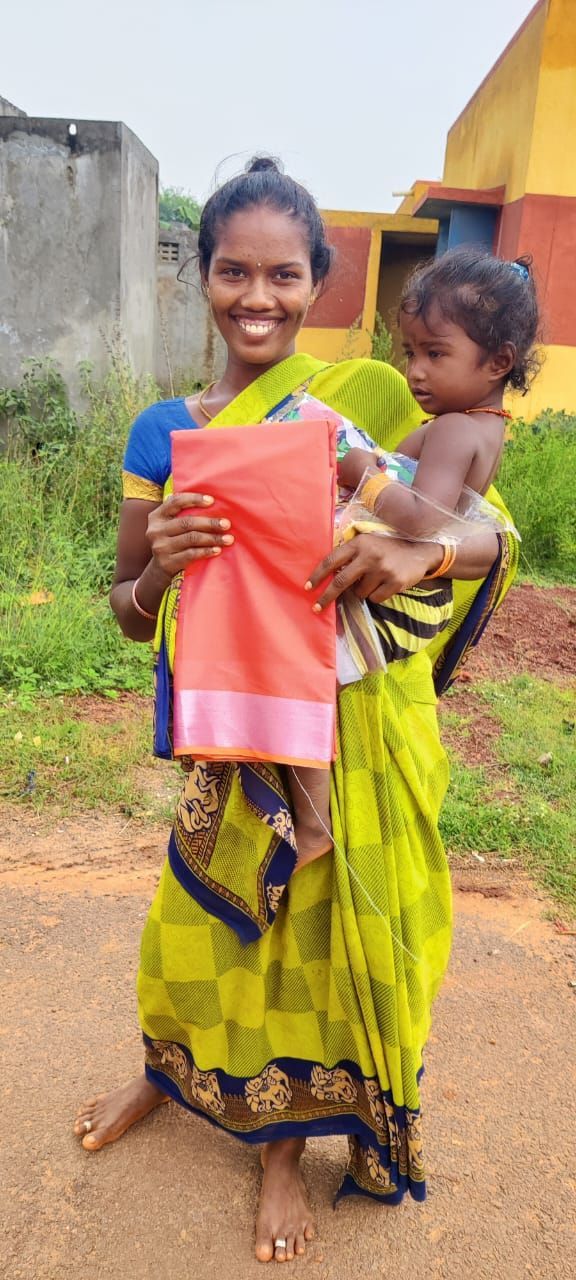 A woman is holding a baby in her arms and smiling.