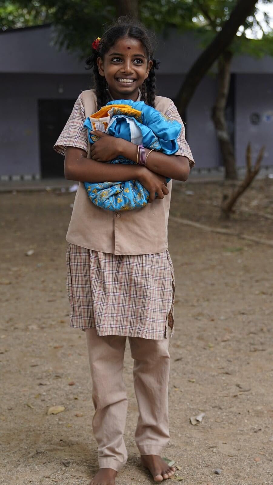 A young girl is holding a stuffed animal in her arms.