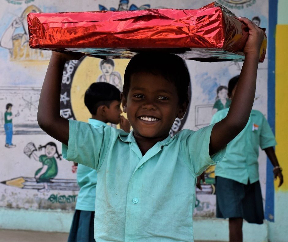 A happy child with a gift from Team Everest donors