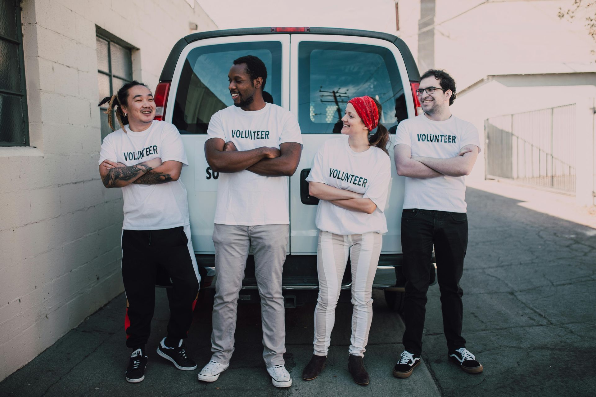 A group of people are standing in front of a van.