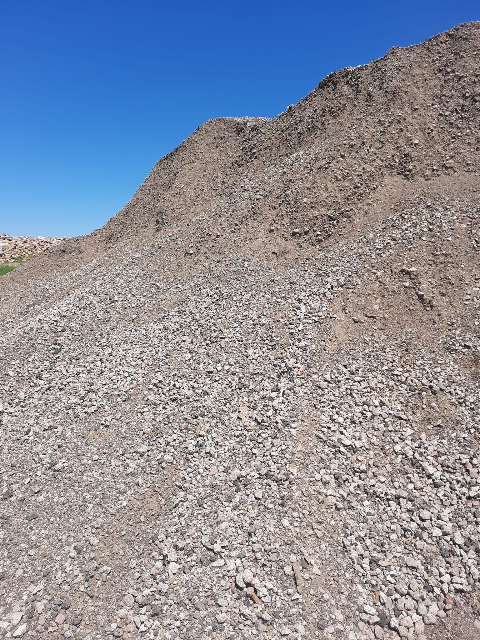 A large pile of gravel is sitting on top of a hill.