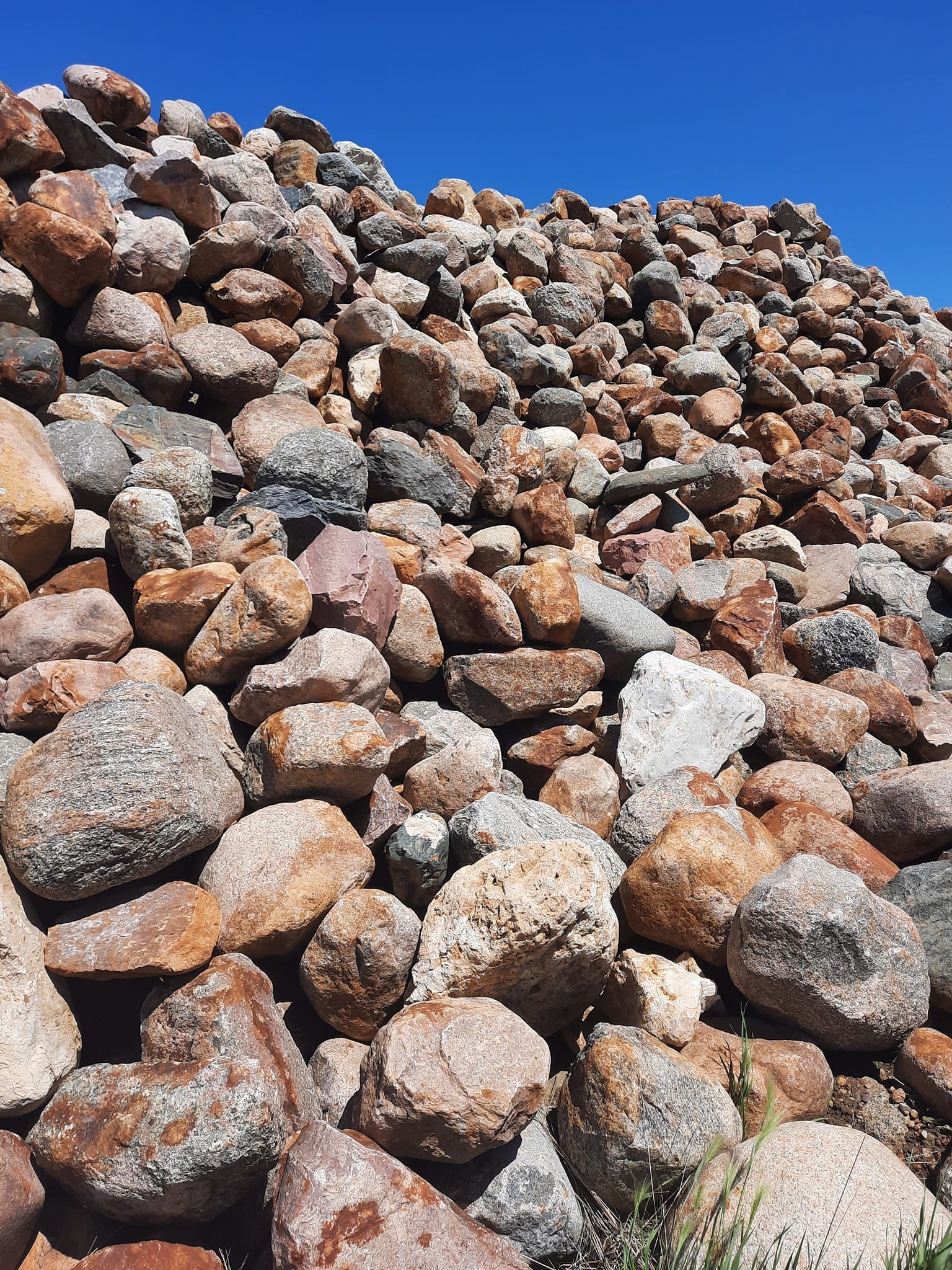 A large pile of rocks against a blue sky.