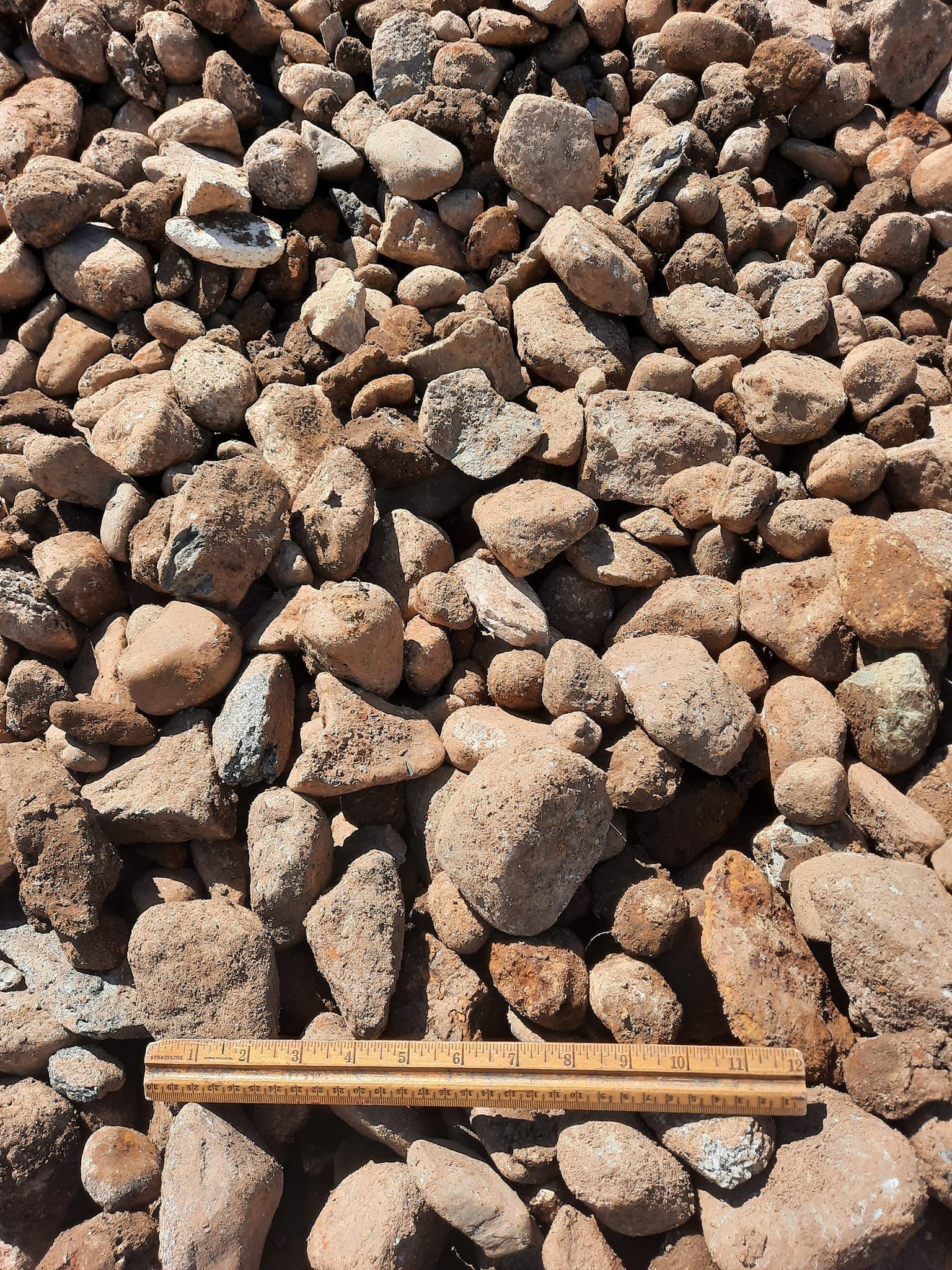 A ruler is laying on top of a pile of rocks.