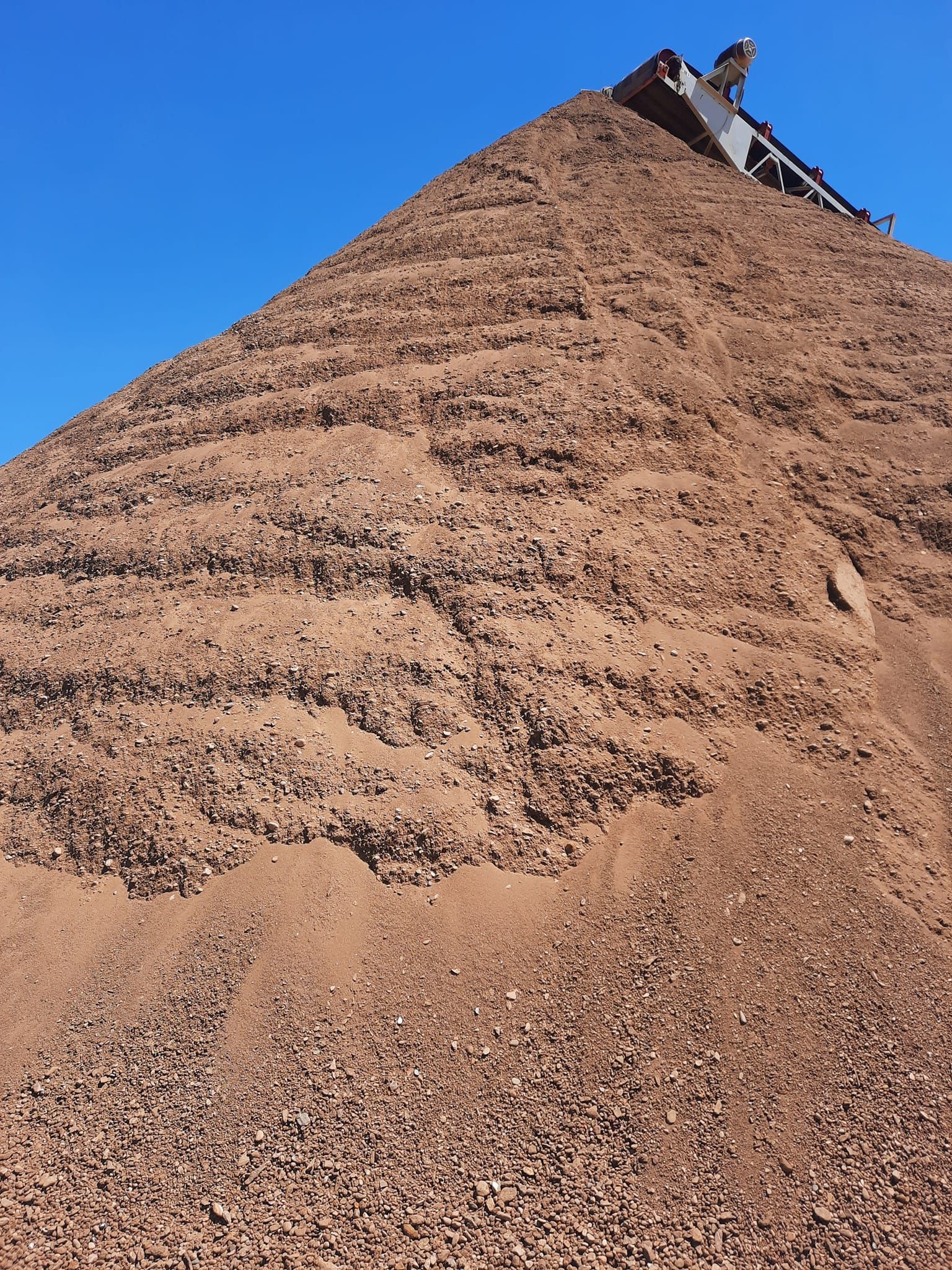 A large pile of dirt is sitting on top of a hill.