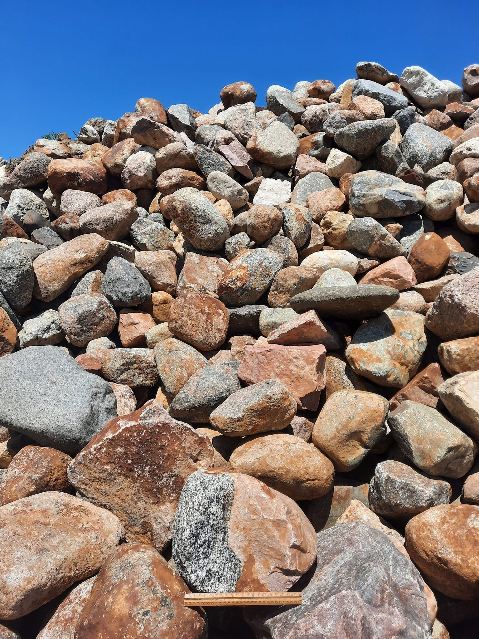 A pile of rocks with a ruler sticking out of it.