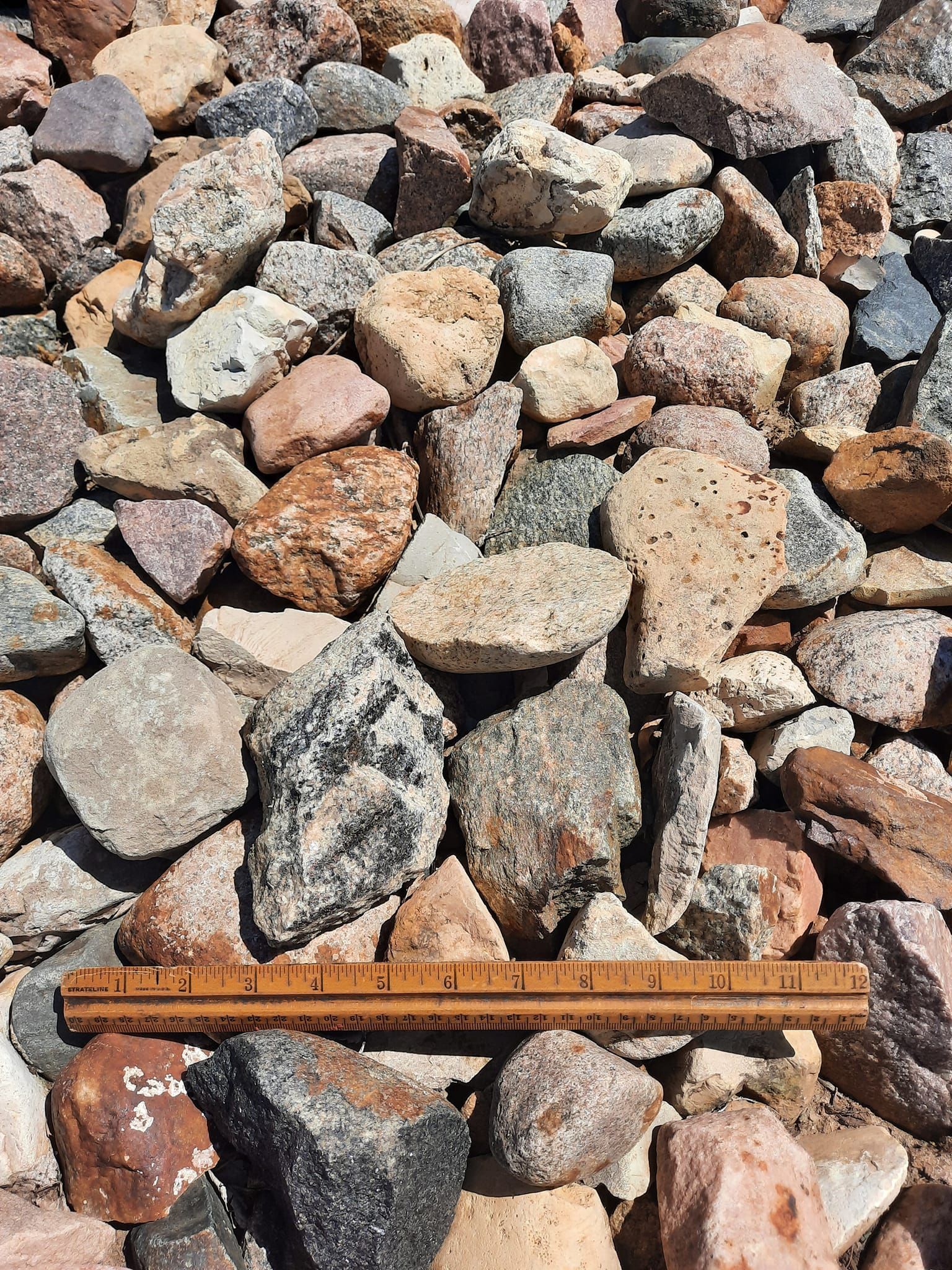 A ruler is sitting on top of a pile of rocks.