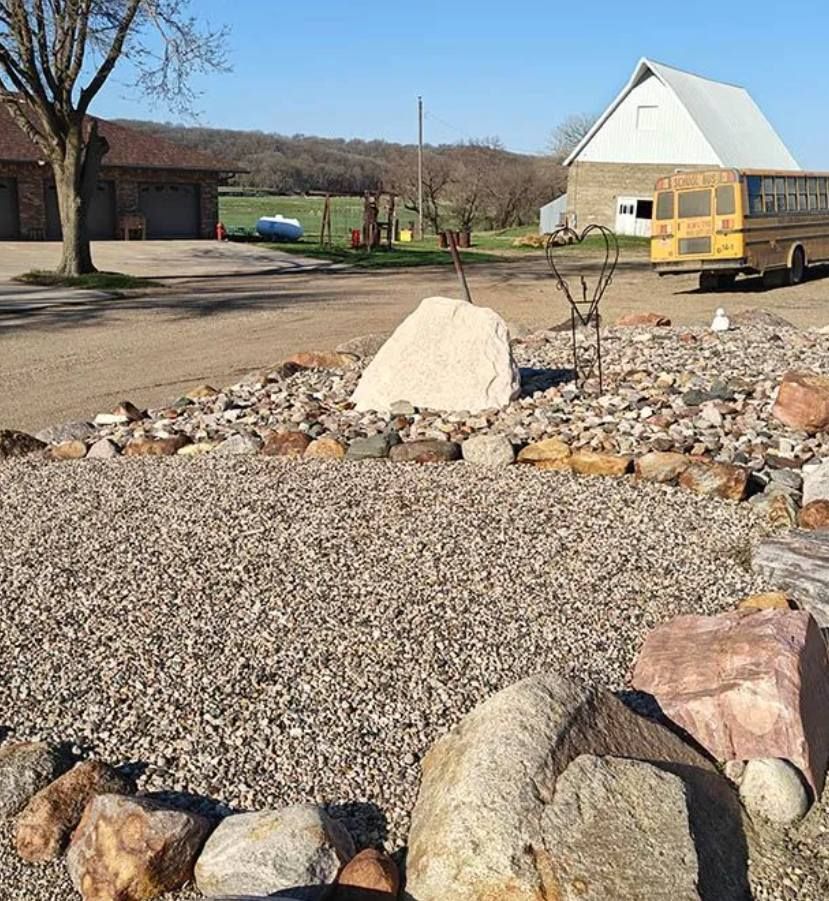 A yellow school bus is parked in a gravel lot