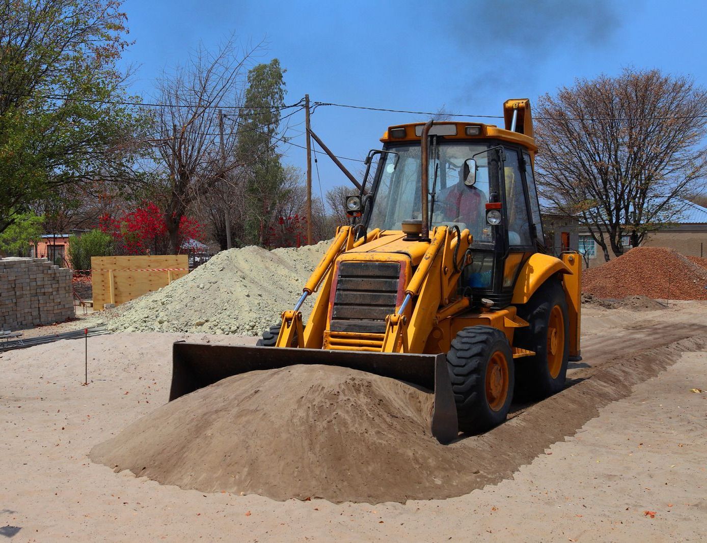 A sandbox filled with sand and toys in a park.