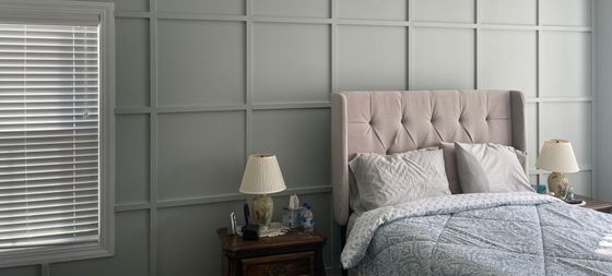 A bedroom with a bed , nightstand , lamps and a window.