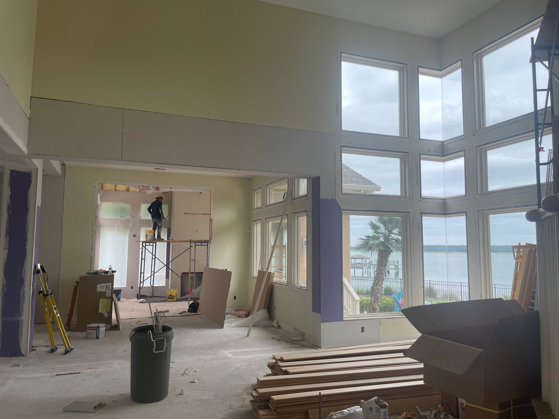 A large room with a lot of windows is being remodeled.