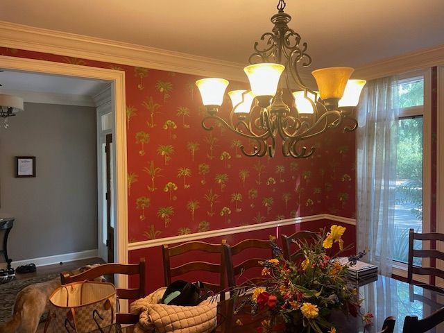 A dining room with red walls and a chandelier