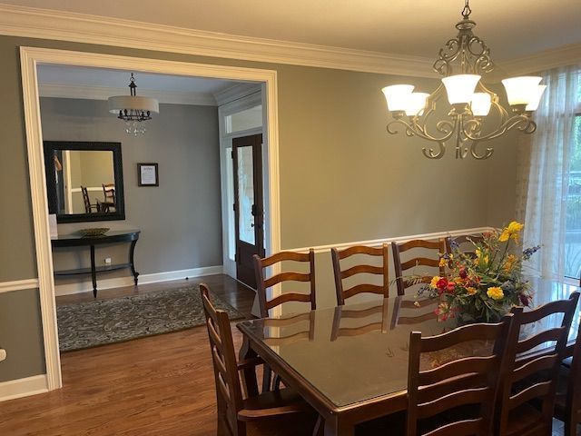 A dining room with a table and chairs and a chandelier