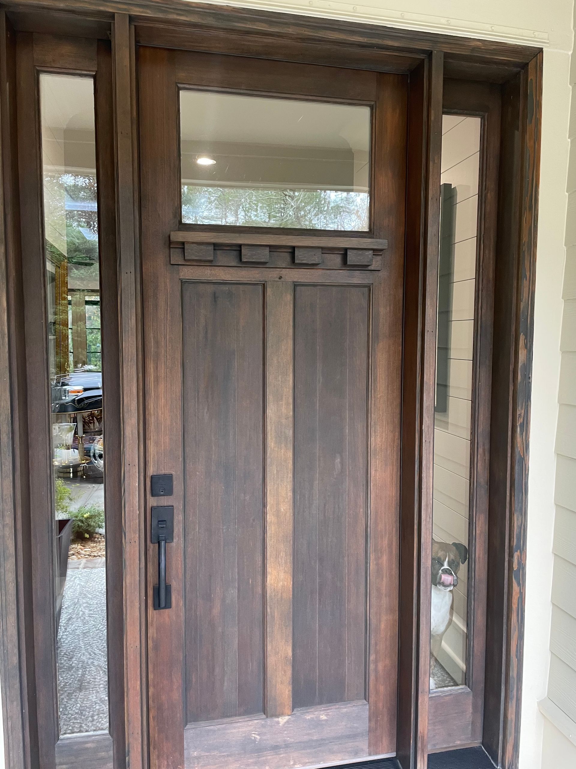 A wooden door with a glass window and a black handle