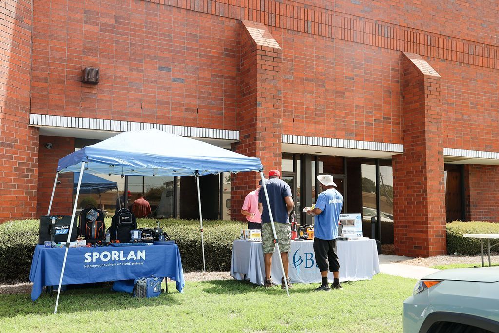 A group of people are standing in front of a brick building.