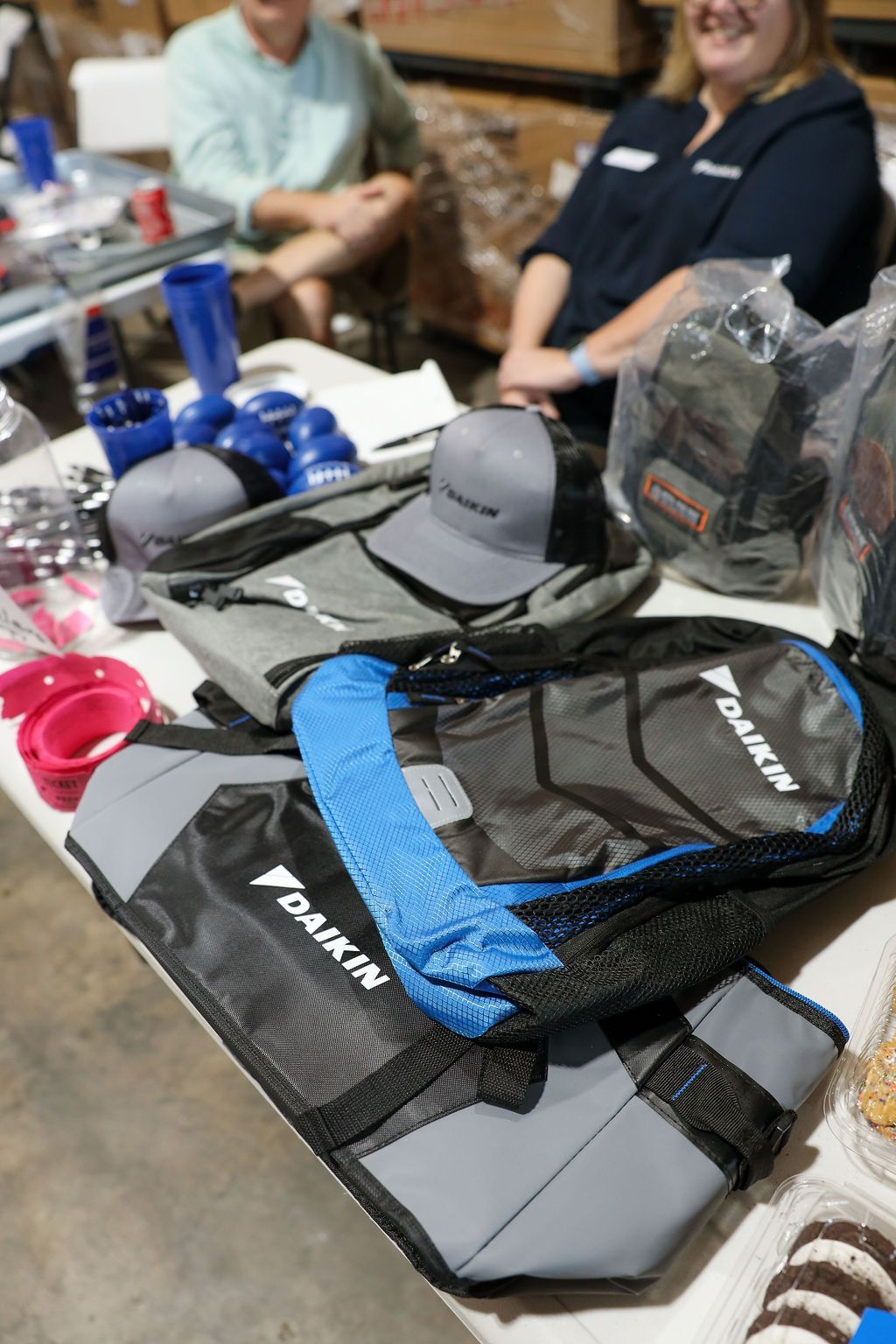 A table with a lot of items on it including a daikin backpack.