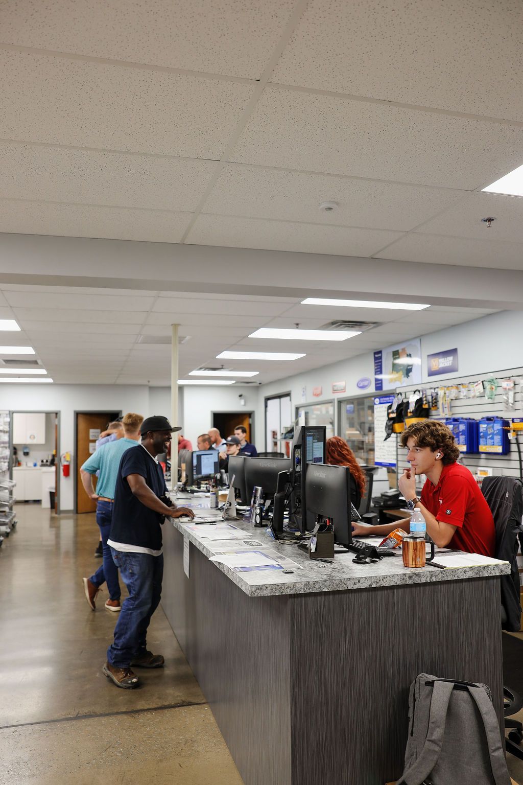 A group of people are standing around a counter in a store.