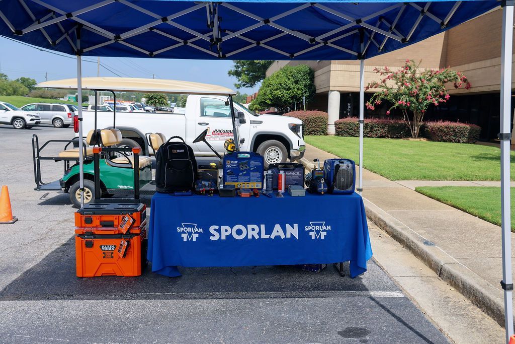 A blue tent with a table underneath it that says sporlan