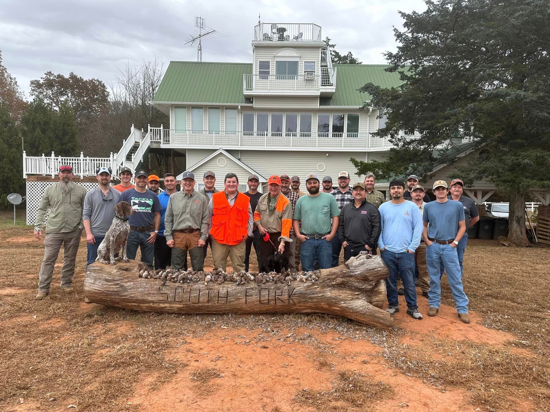 A group of men are posing for a picture in front of a house.