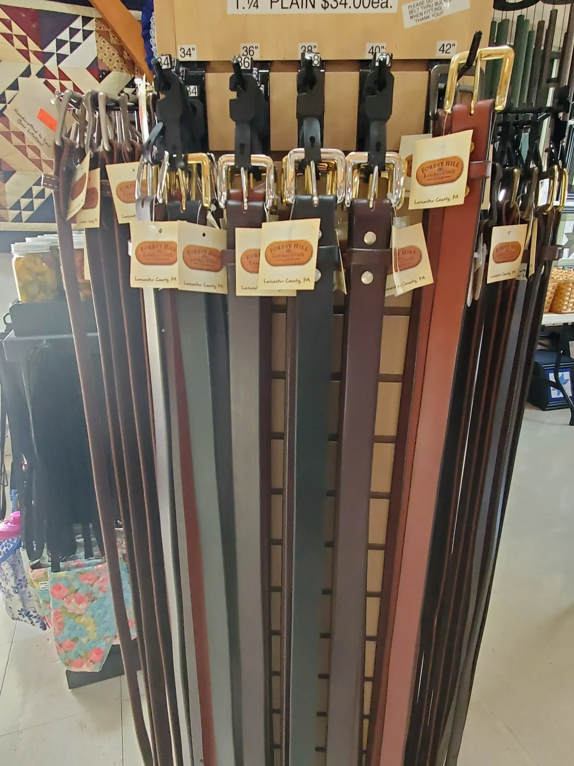 A bunch of belts are hanging on a rack in a store
