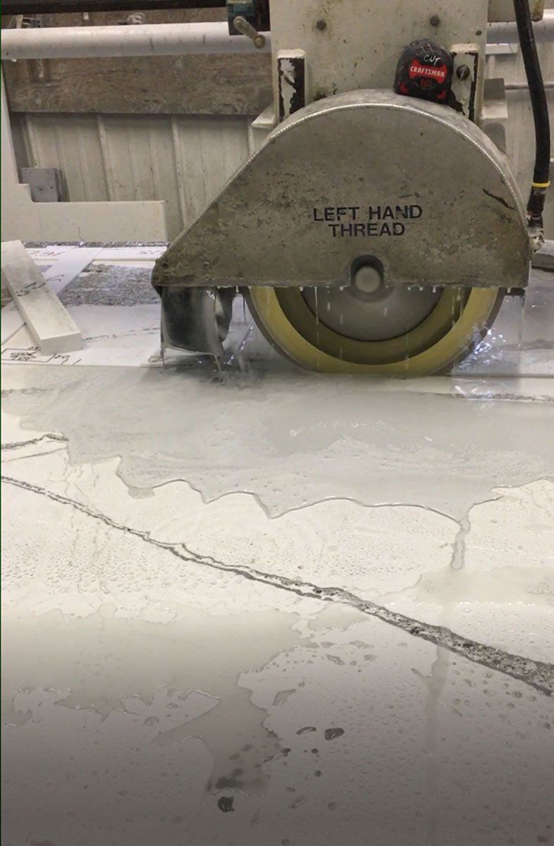 A machine is cutting a concrete floor with a yellow wheel.