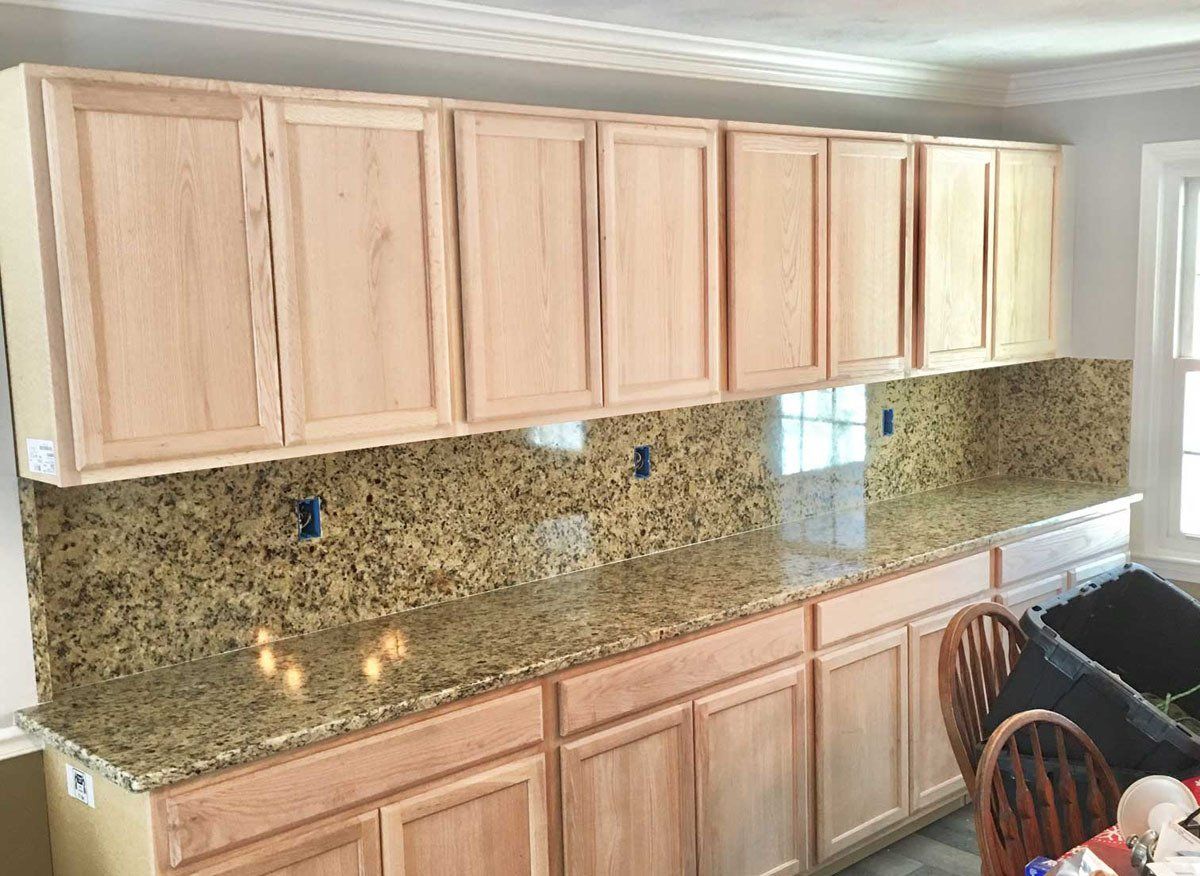 A kitchen with wooden cabinets and granite counter tops.