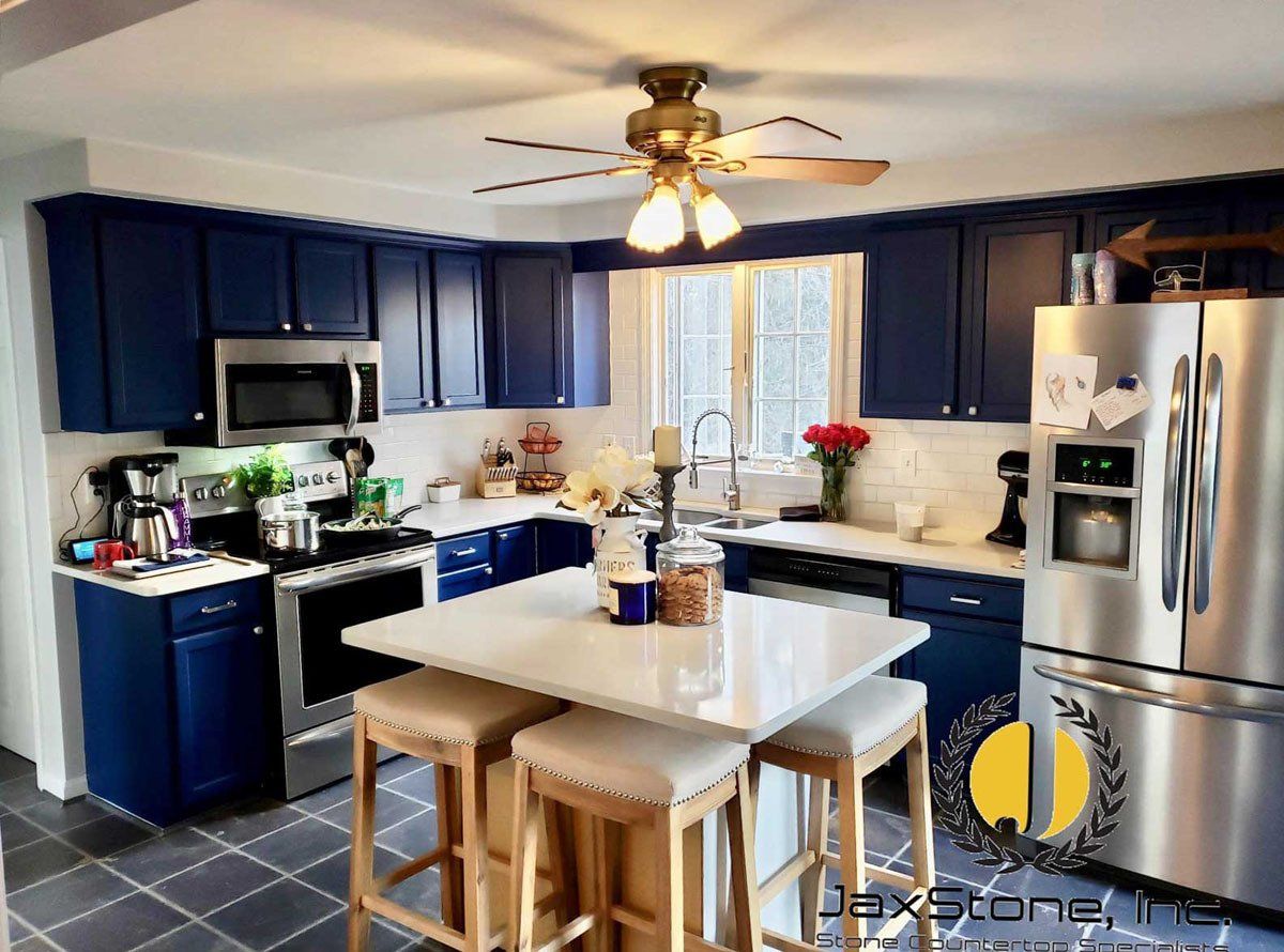 A kitchen with blue cabinets and stainless steel appliances