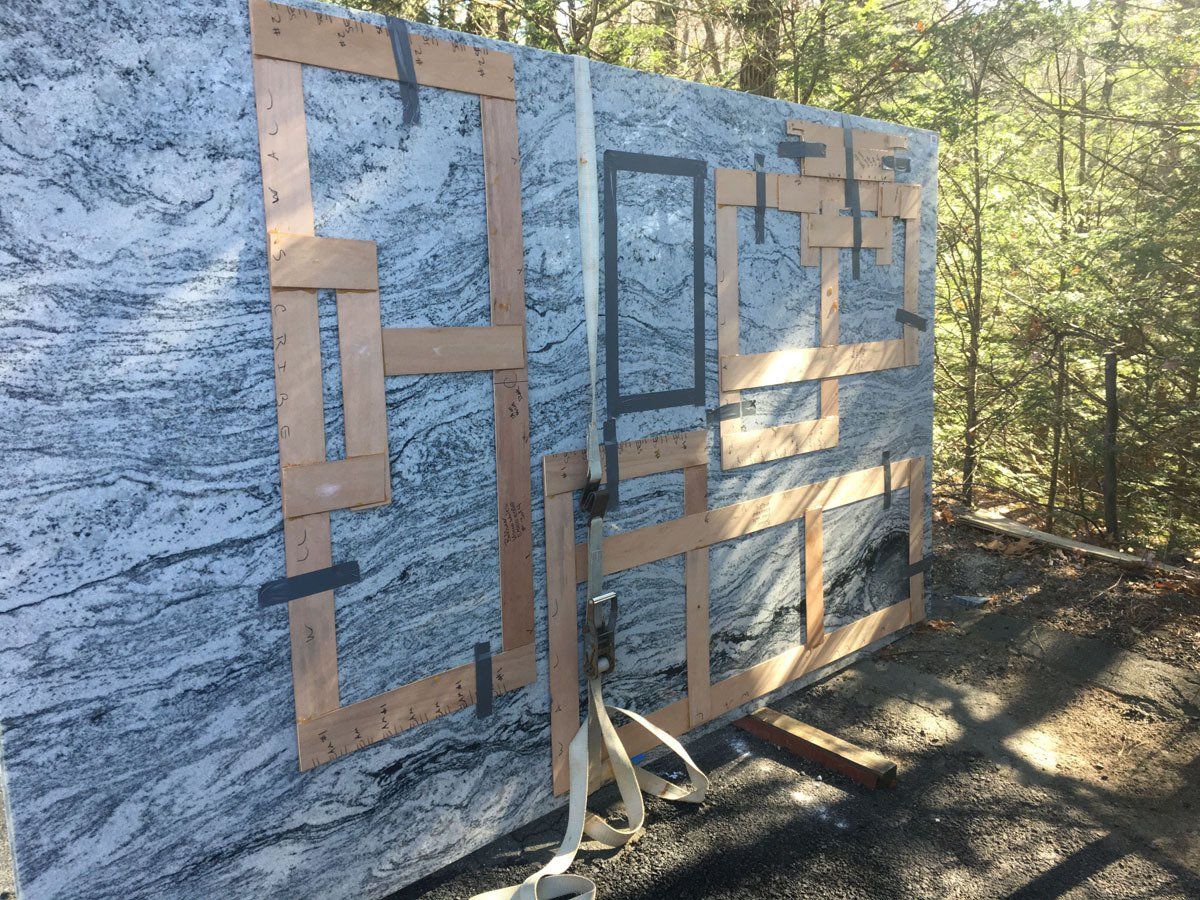 A large slab of granite is being loaded on a truck