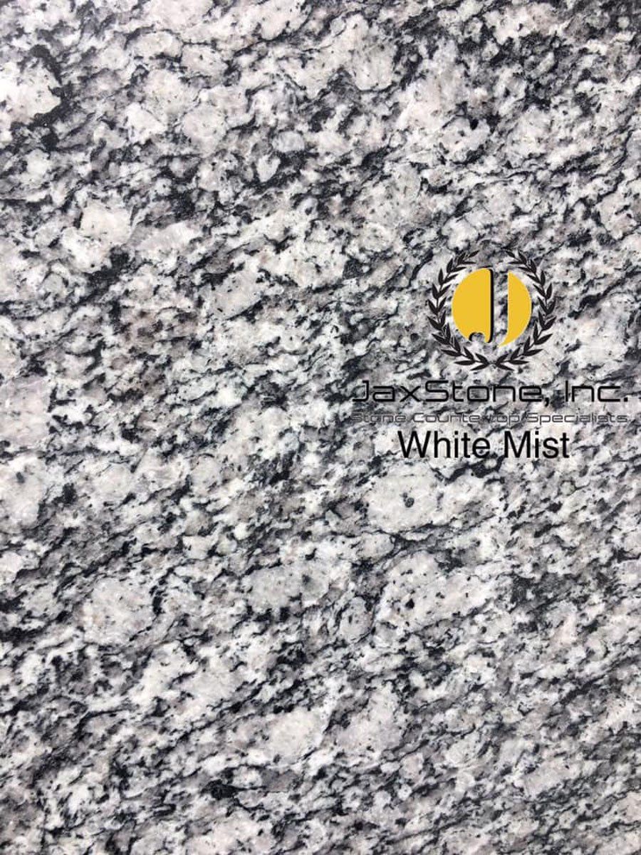 A close up of a white mist granite counter top.