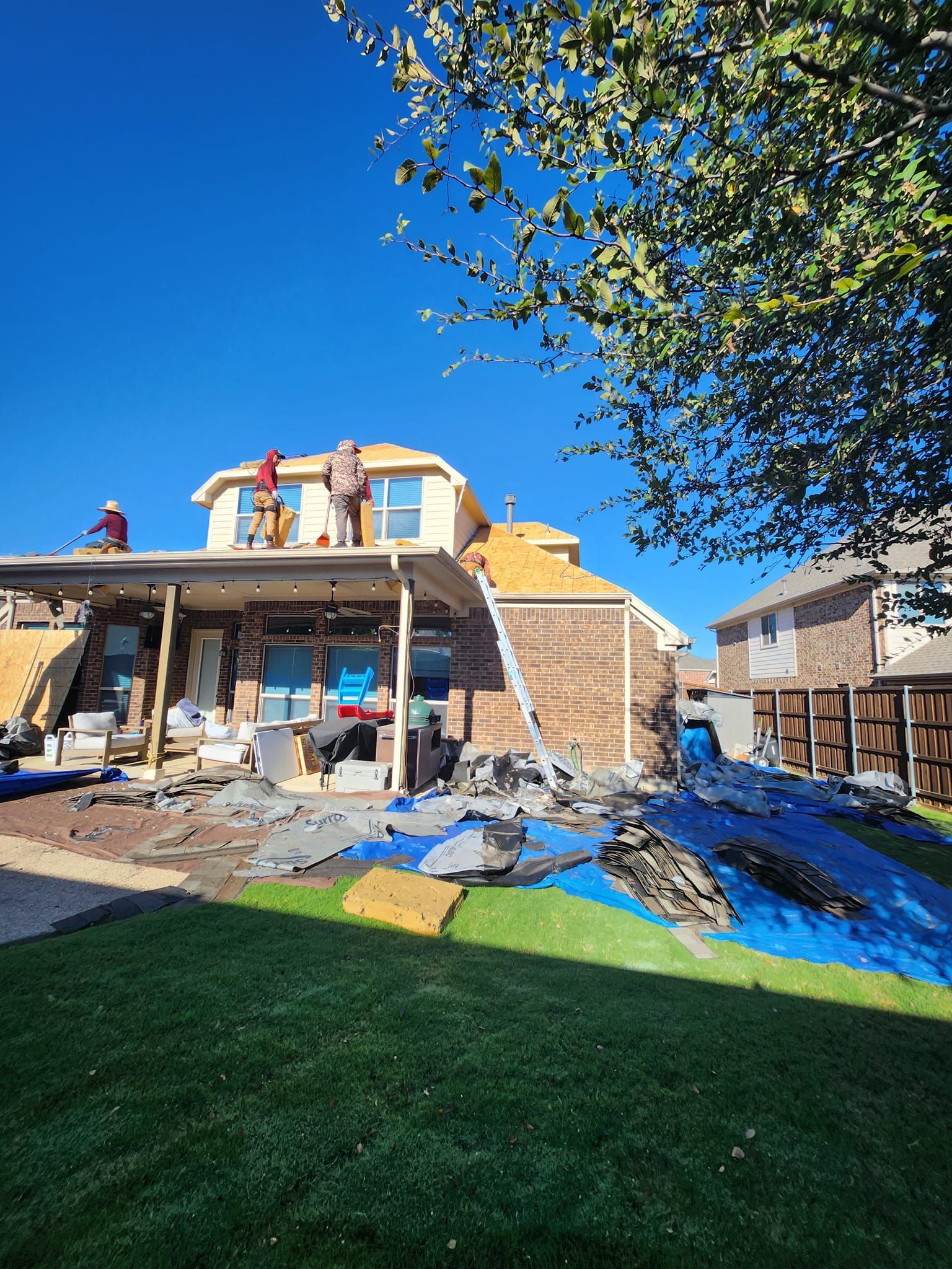 A group of people are working on the roof of a house.