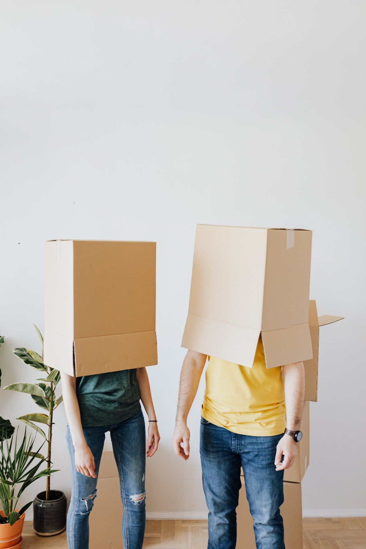 2 persons with boxes over there heads