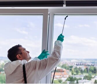 Exterminators Spraying The Window — Pest Control Technicians in Parlin, NJ