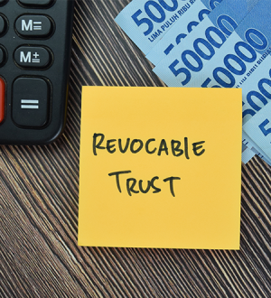 A yellow sticky note with revocable trust written on it