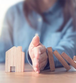 A woman is playing with wooden blocks on a table.