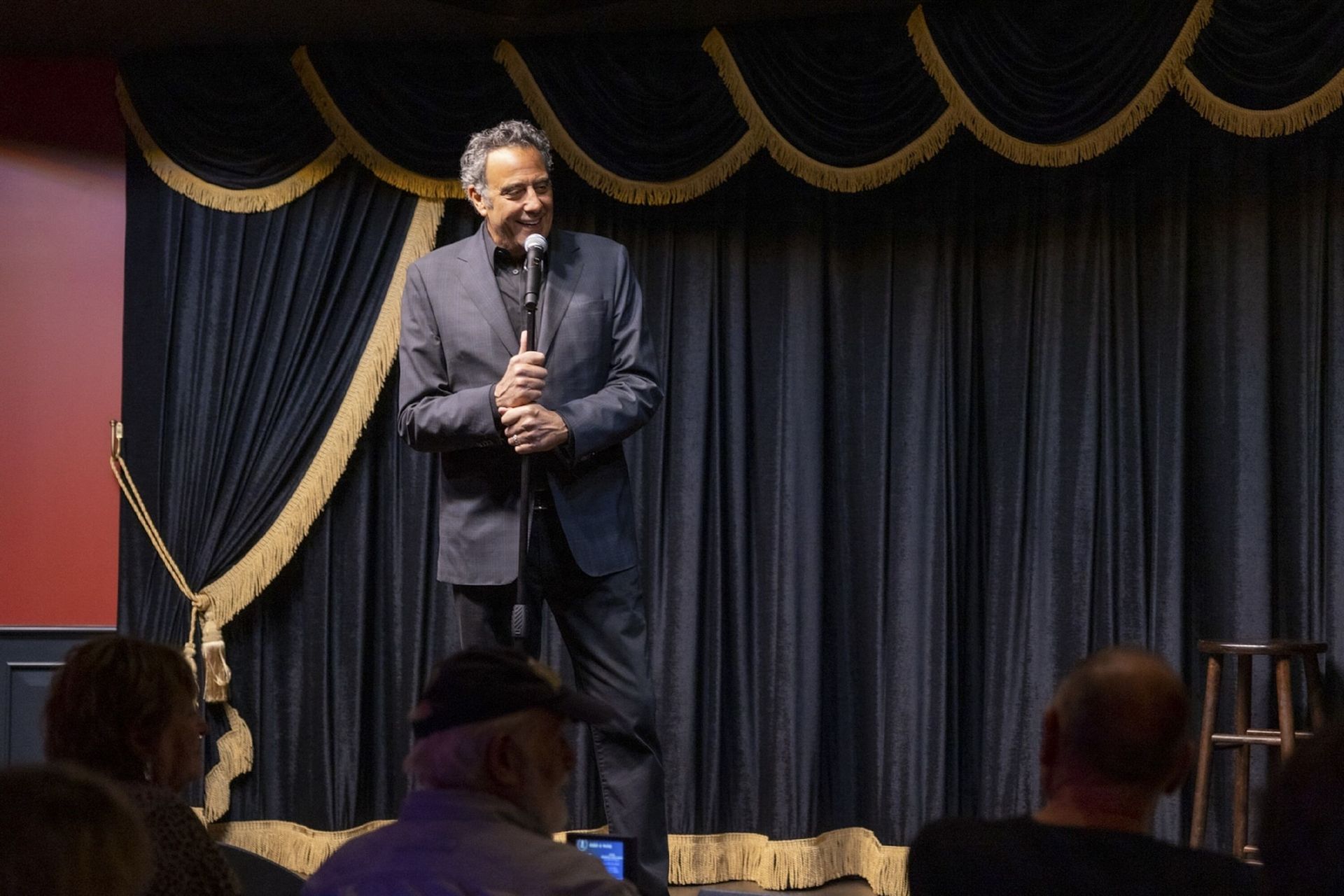 a man in a suit is standing on a stage holding a microphone .
