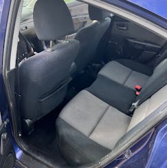 The inside of a blue car with black and grey seats.