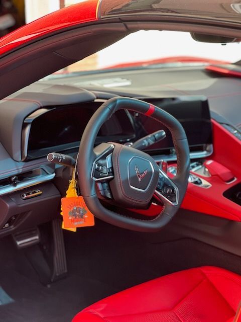 The interior of a red sports car with a steering wheel