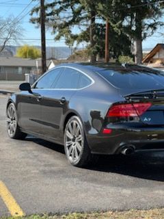 A black audi a7 is parked in a parking lot.