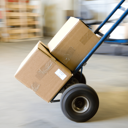 Two cardboard boxes on a hand truck in a warehouse