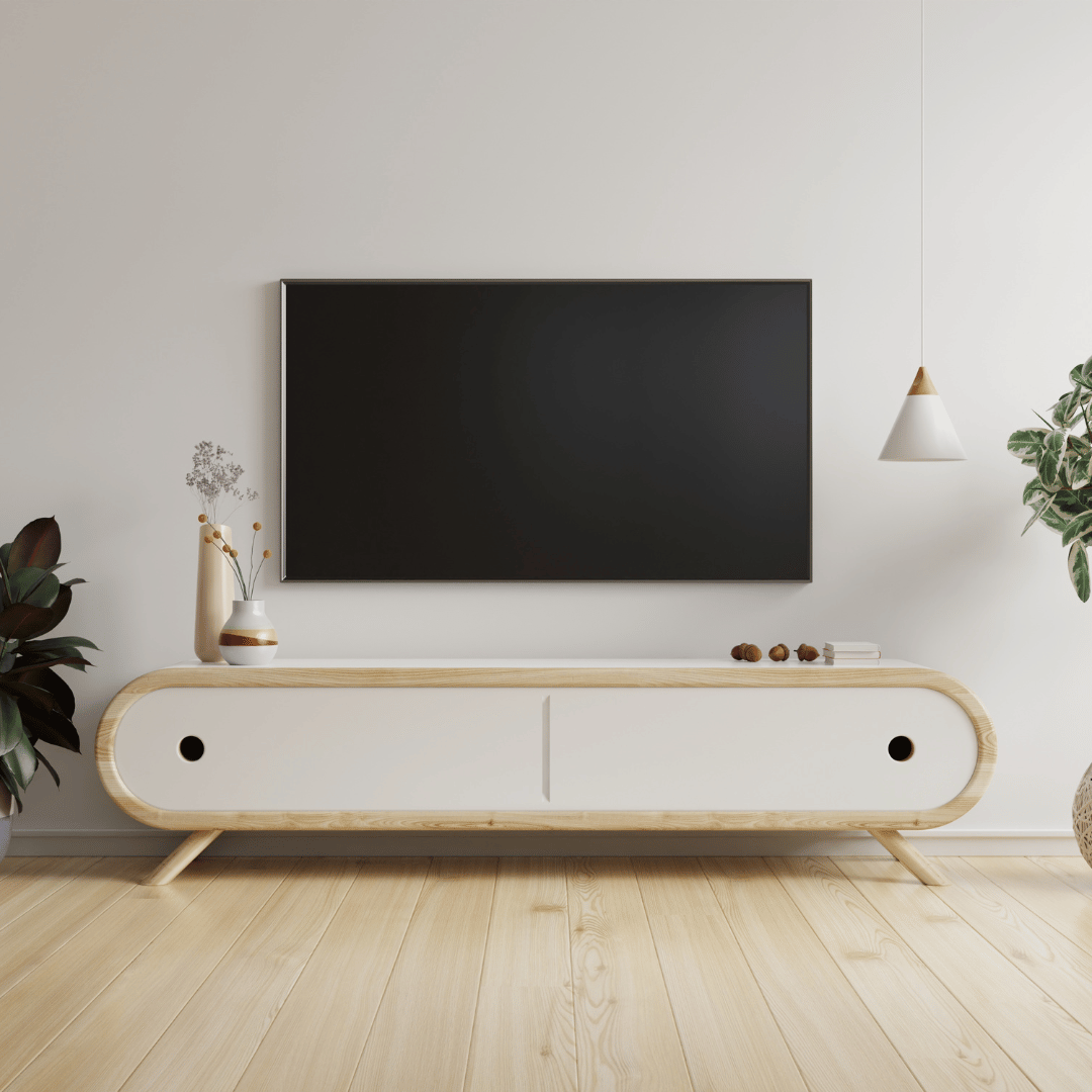 A living room with a flat screen tv on the wall above a wooden entertainment center.