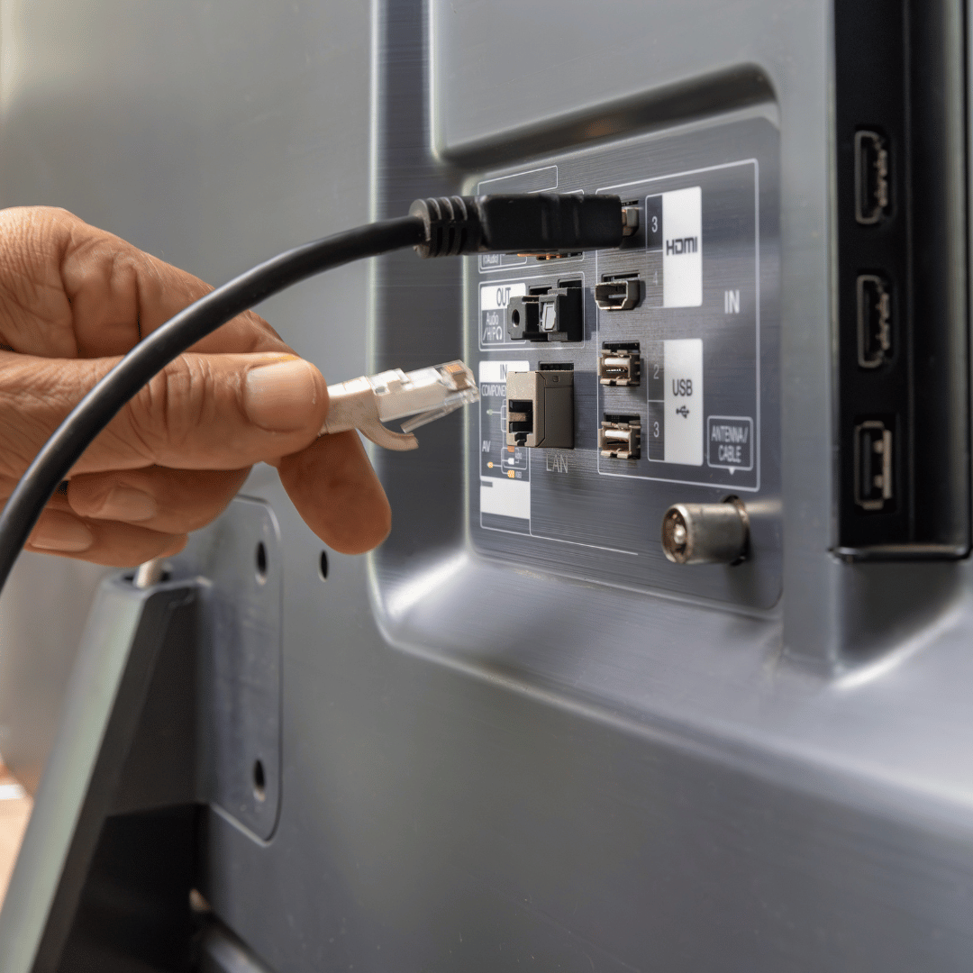 A person is plugging a cable into a tv