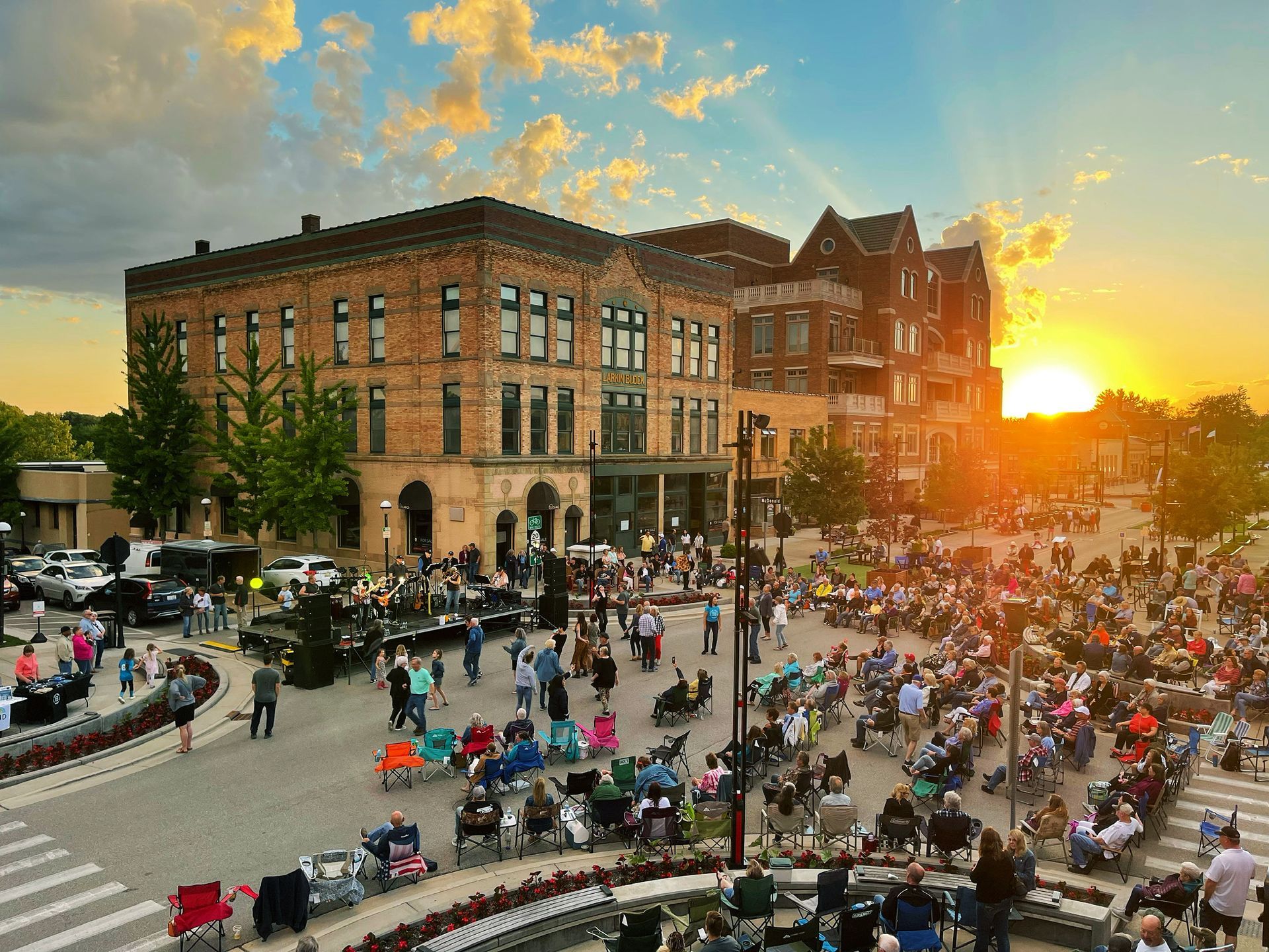 House with blue and white exterior, green lawn, trees, and bright blue sky.