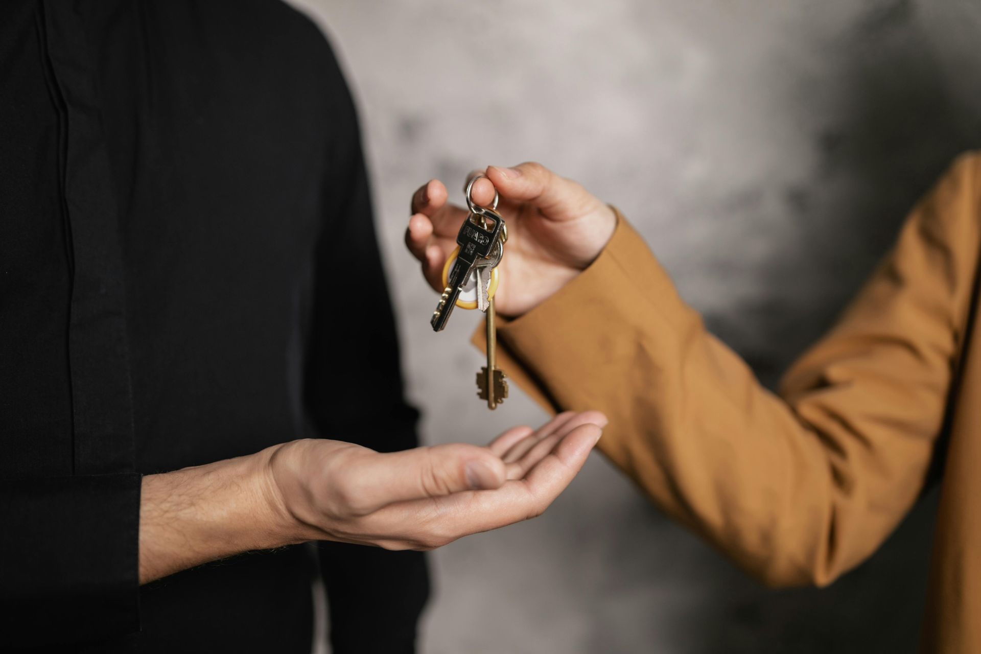A man is giving a woman a bunch of keys.