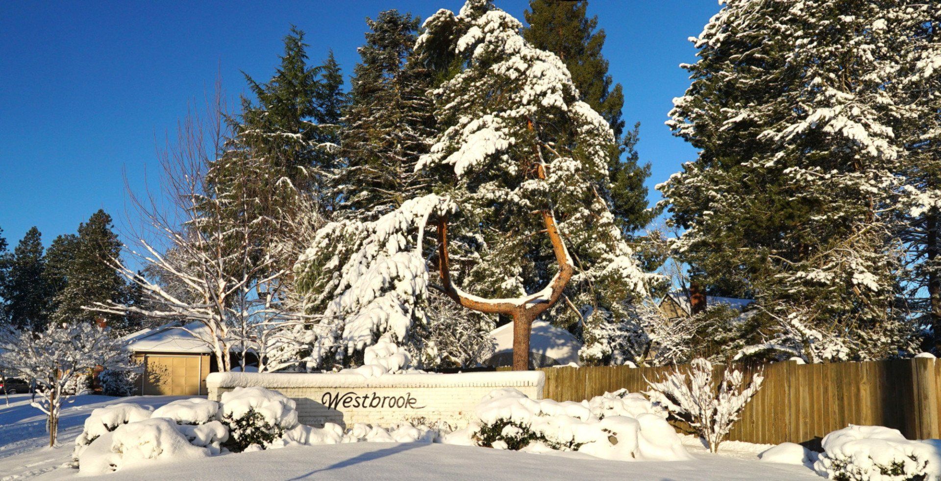 A snowy landscape with a welcome sign in the foreground