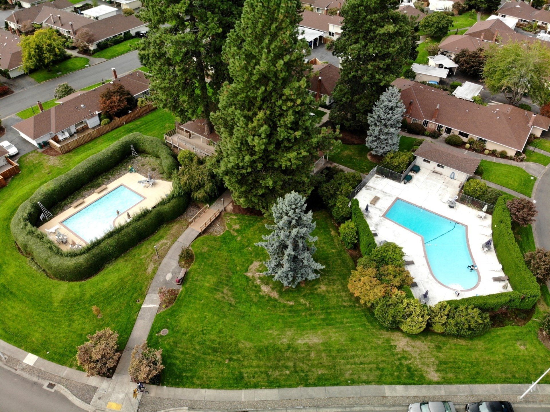 An aerial view of a residential area with two swimming pools