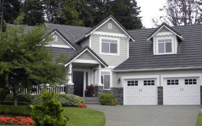 Suburban gray house with white trim, two-car garage, and landscaped front yard