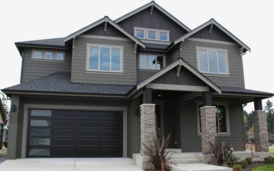 Gray two-story suburban house with dark trim, garage, and front porch